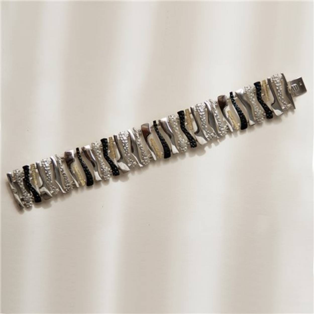 Zilveren armband met gouden en geoxideerde accenten.
