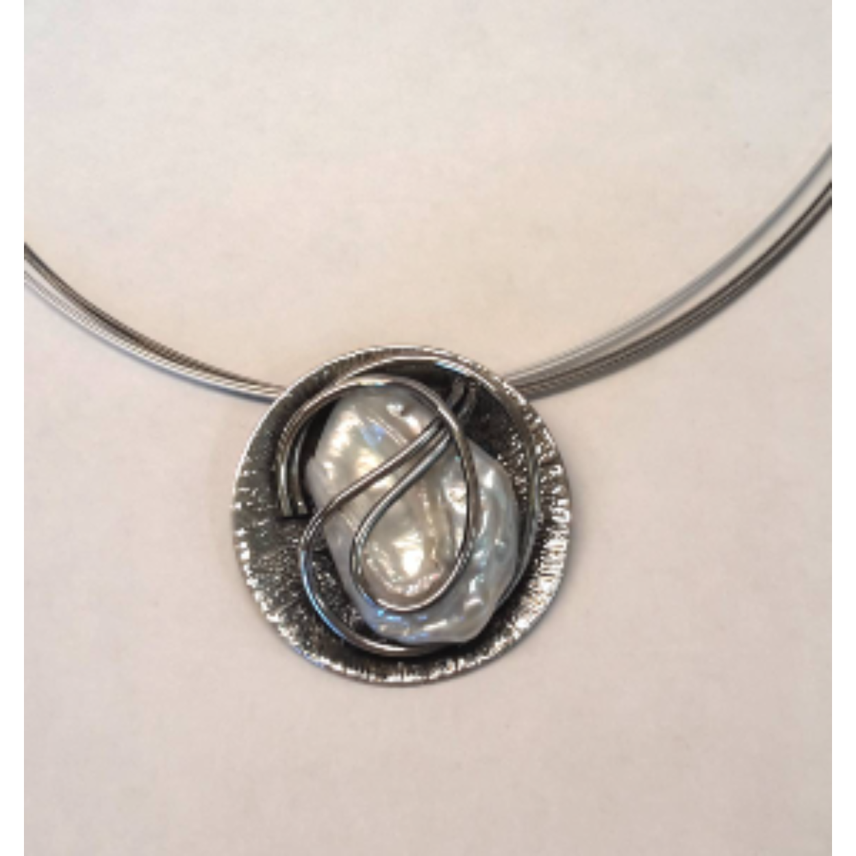 Buttner Schmuck handgemaakte sieraden vervaardigd in een klein atelier uit de Harz, zilveren hanger met zoetwater parel en staaldraadcollier.