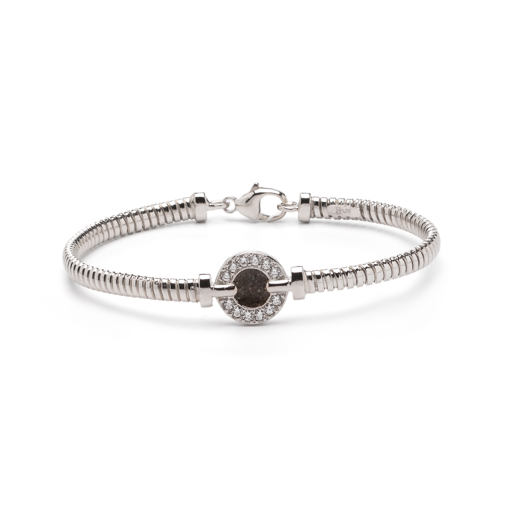 Zilveren armband gezet met zirkonia. In het midden van de asarmband bevindt zich een ornament met zirkonia’s. Dit sieraad wordt zichtbaar aan de voorkant gevuld met as en wordt vermengd met onze speciale hars. U kunt dit helaas niet zelf vullen.