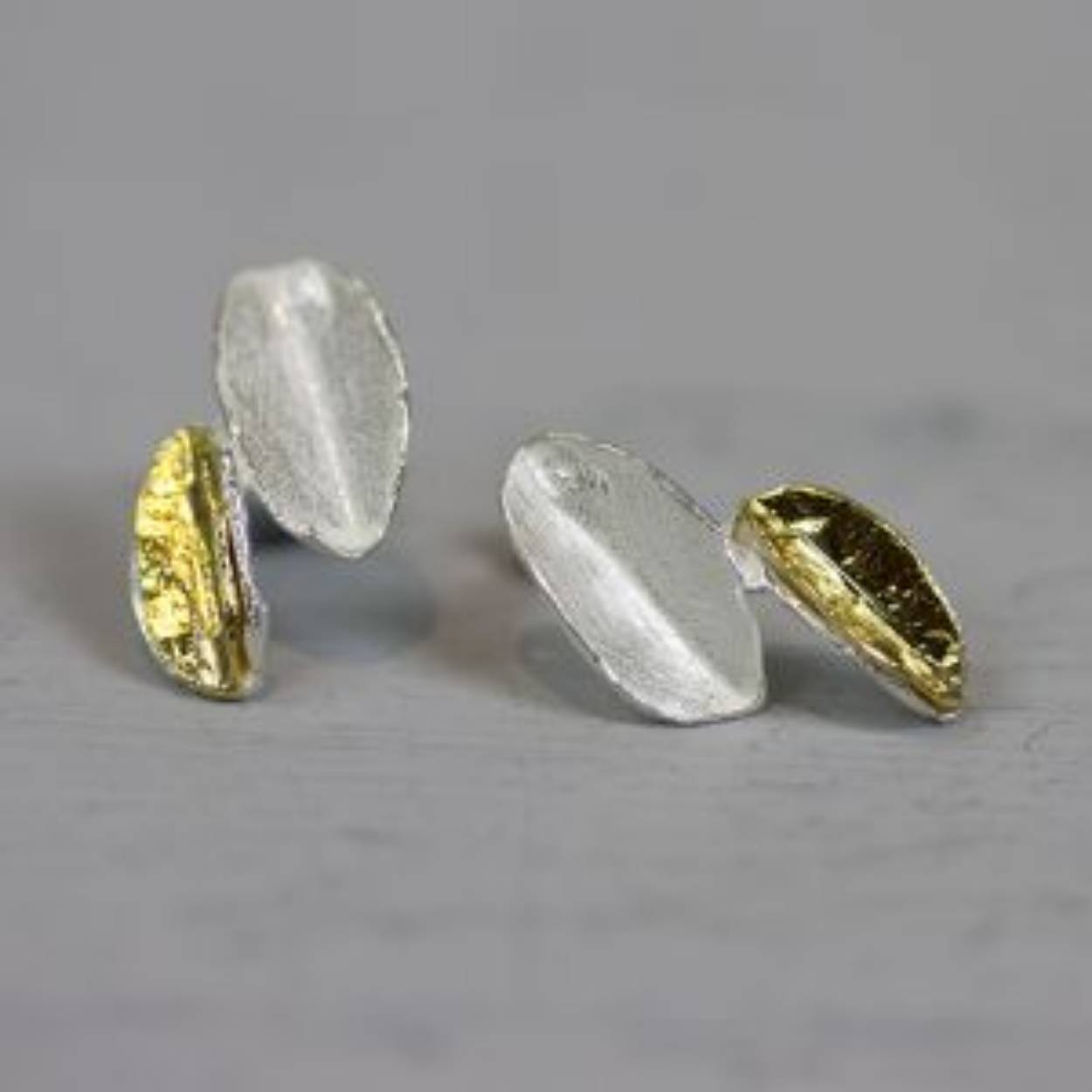Oorbel gemaakt van 925 sterling zilver en verguld zilver in de vorm van twee bladeren.

Materiaal: 925 sterling zilver
De glans van 925 sterling zilver maakt het een gewild edelmetaal voor de vervaardiging van sieraden. Het bestaat uit 92,5% puur zilver en 7,5% koper. Puur zilver is een zacht en buigzaam materiaal, het koper in 925 sterling zilver zorgt voor de stevigheid. De sieraden van Jéh Jewels zijn nikkel vrij.

Materiaal: Zilver verguld
Vergulden is het bedekken van een voorwerp met een laagje goud. Dit artikel is door een goudbad gehaald wat ervoor zorgt dat het zilver volledig bedekt wordt met een laagje goud. Resultaat een mooie glanzende afwerking met een laagje echt goud wat ook wel silverplated of goldplated wordt genoemd.