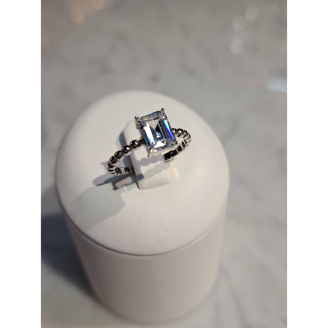 14 Karaat wit gouden ring met bolletjes en in het midden baguette geslepen zirkonia.