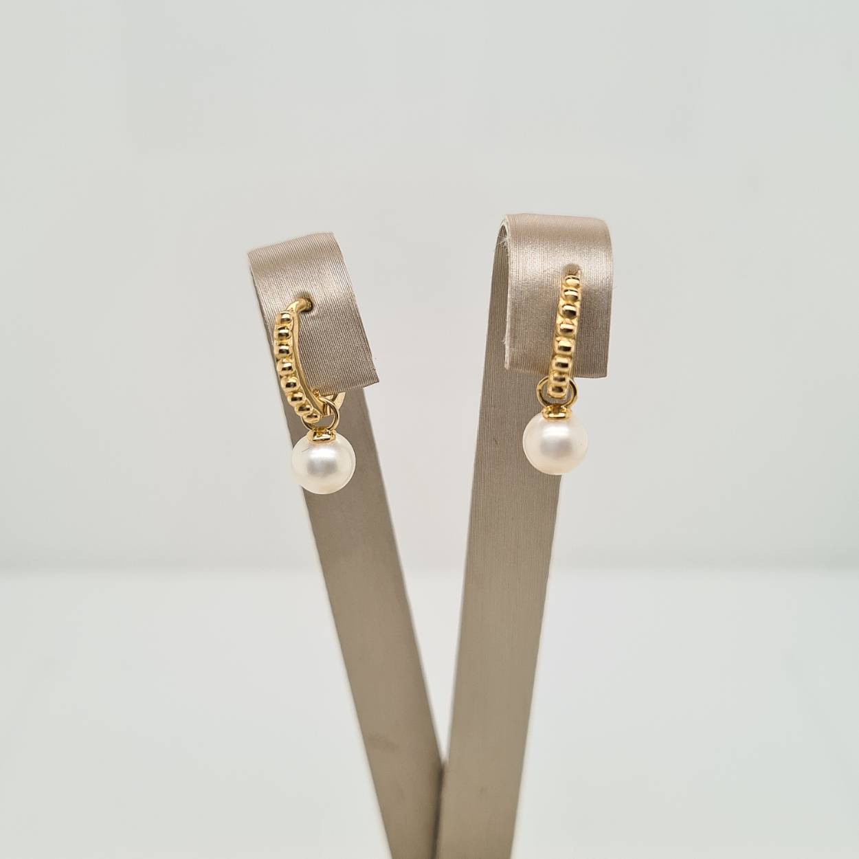 14krt geelgouden parel klapoorringen. De klapoorringen hebben een afmeting van 10.5x1.5mm en de parel heeft een diameter van 5.5mm.