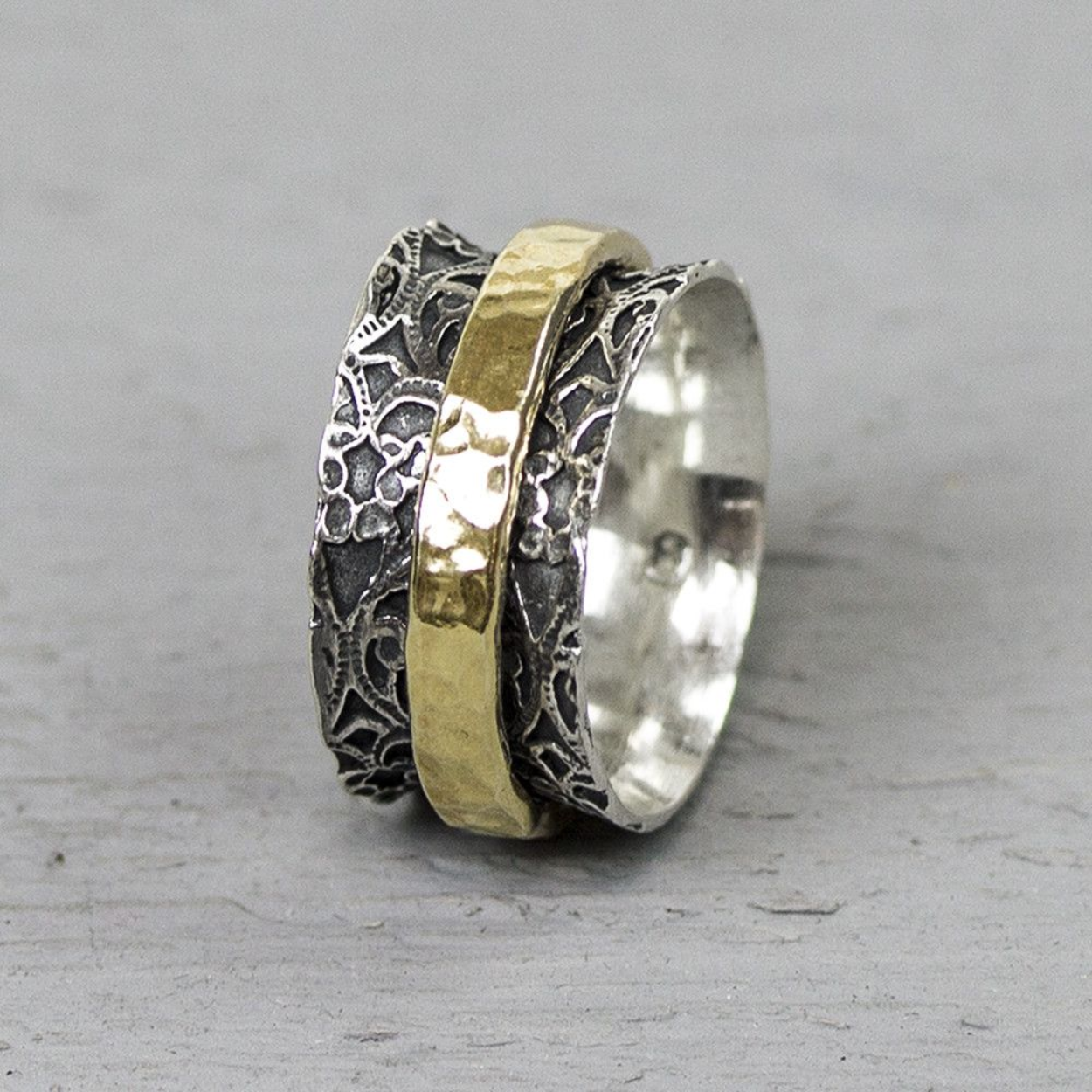 Ring gemaakt van 925 sterling zilver, geoxideerd zilver en goldfilled. De basis ring heeft een motief van kant