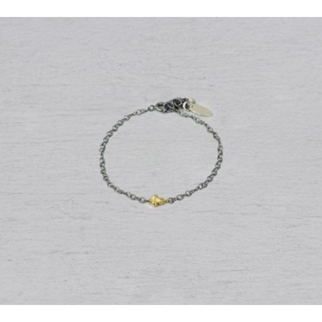 Armband gemaakt van 925 geoxideerd sterling zilver met daaraan een trosje van 9 karaat. Combineer met het bijpassende collier. De armband is verstelbaar waardoor je hem ook op een andere lengte kunt dragen.