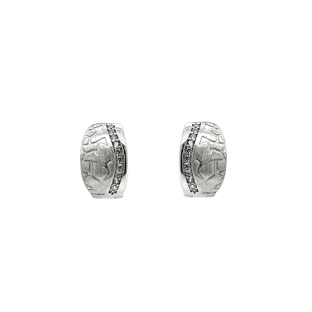 Deze 925 zilveren klapoorringen hebben een mooie en solide uitstraling. De oorringen zijn op een bijzondere wijze bewerkt. Een gedeelte is gematteerd en fantasierijk bewerkt, een gedeelte is glad gepolijst en de rij met zirkonia stenen zorgt voor de nodige schittering.