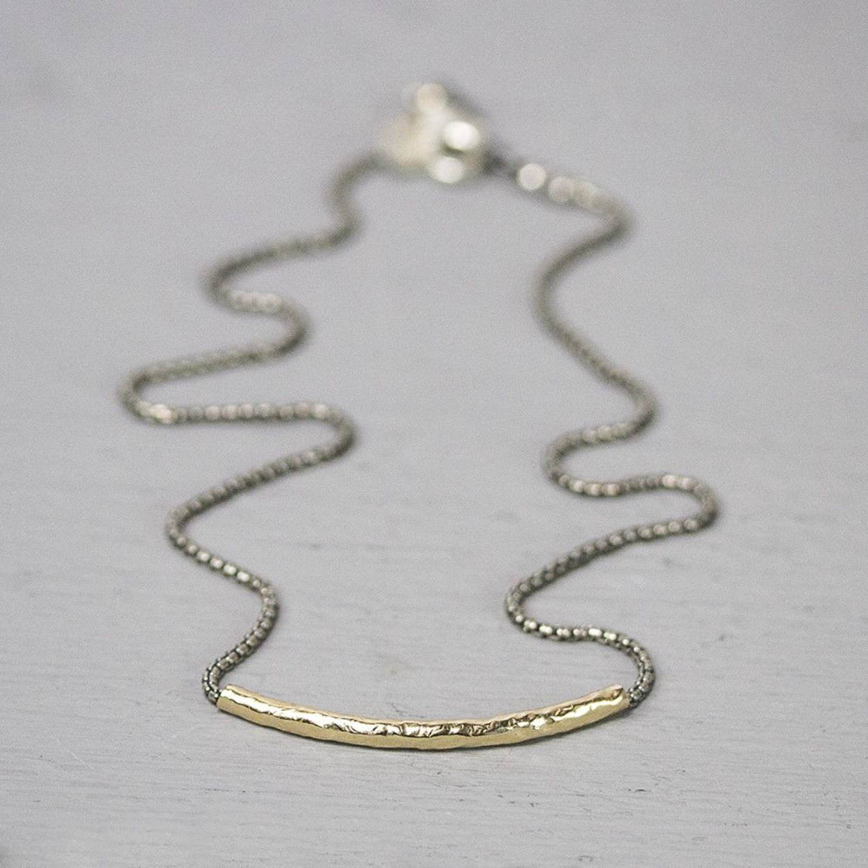Collier gemaakt van 925 sterling geoxideerd zilver met daaraan een rond lopende buis van goldfilled.
