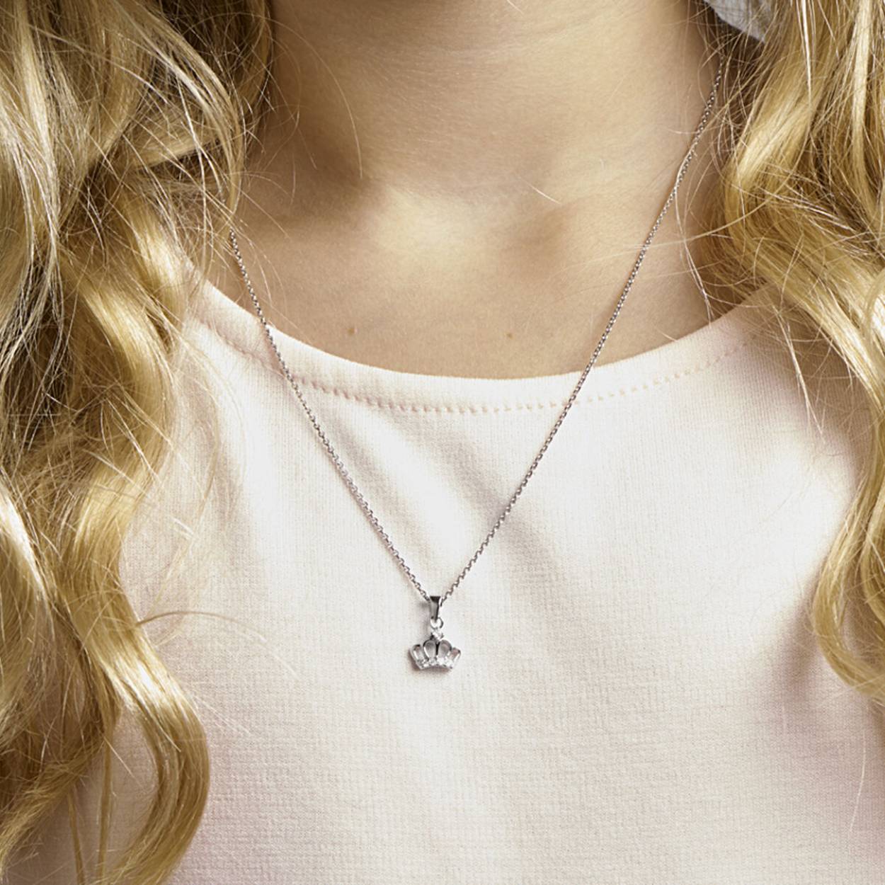 Schattig gerhodineerd zilveren collier met een hanger in de vorm van een kroontje met een afmeting van 15x10mm. De schakelbreedte is 1.1mm. Uitgevoerd met schitterende zirkonia en een stevig hangoog. Het collier heeft een draaglengte van 36cm en een extensie van 4cm. Perfect te combineren met bijpassende sieraden uit onze collectie. Tip: Leuk om kado te geven! Info: Gerhodineerd zilver is door de rhodiumlaag beter bestand tegen verkleuren en krassen.