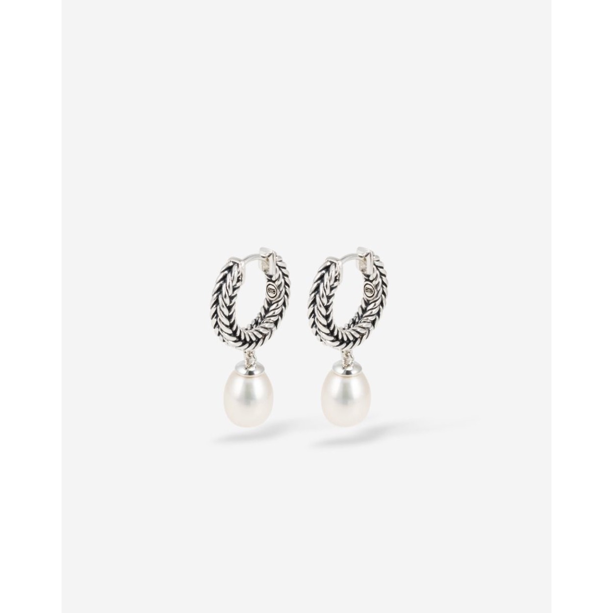  

De Hoops Barbara Parel combineren tijdloze schoonheid met een gedurfd ontwerp. Met natuurlijke witte ovale zoetwaterparels voegen deze oorbellen een vleugje luxe toe aan de opvallende zilveren afwerking. De textuur op de oorbellen is geïnspireerd op het iconische Barbara-weefpatroon en creëert een boeiend contrast tussen het gedetailleerde ontwerp en de gladde, stralende parels. Gemaakt van hoogwaardig gerecycled 925 sterling zilver, bieden deze oorbellen zowel verfijning als duurzaamheid. Vier de schoonheid van contrast en vakmanschap met de Barbara Pearl Zilver Hoops, een perfecte mix van natuurlijke elegantie en iconisch design.