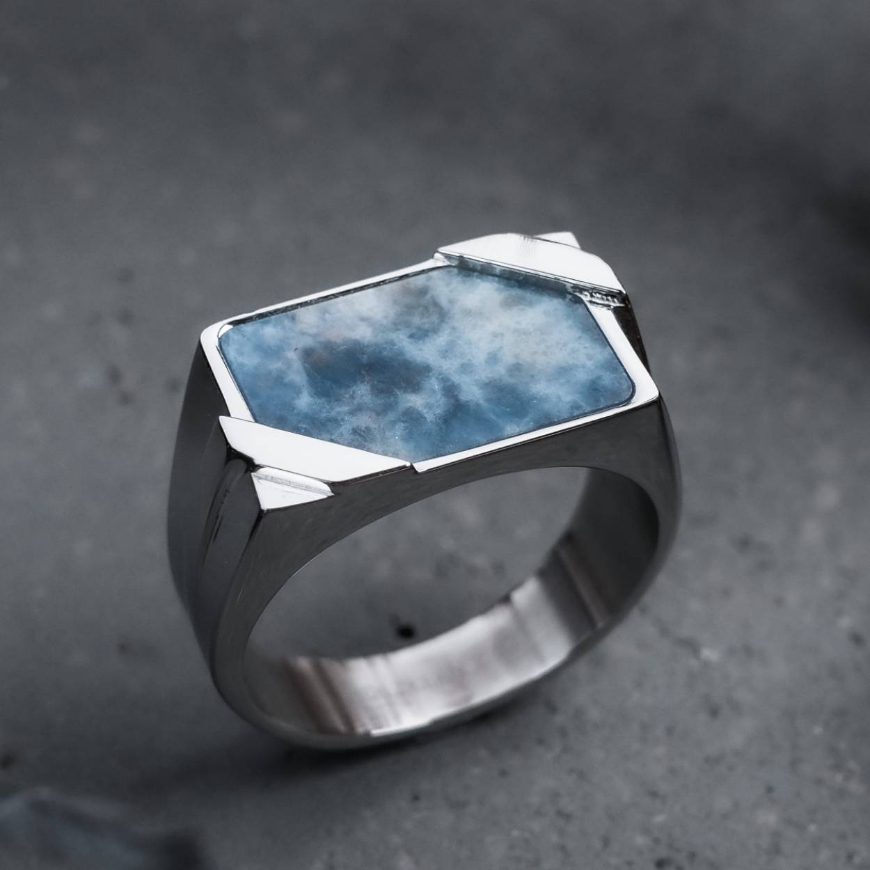 A binomial is simply the sum or the difference between two parts, for example a+b or a-b. The binomial formulas (a+b)2 and (a-b)2 are derived from this.

Our “Binomial” signet ring is crafted from high-quality 316L stainless steel in silver and the rare and fascinating mineral sodalite. With sodalite, did you know that both fluorescence and phosphorescence is possible under UV light? Discover your new daily companion and wear your own personal piece of raw nature by your side!