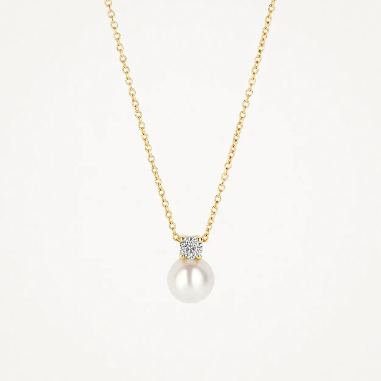Dit 14k geelgouden collier wordt gesierd door een hanger met parel en zirkonia in chaton-zetting. Het collier heeft een lengte van 42 cm en een veerringsluiting. 