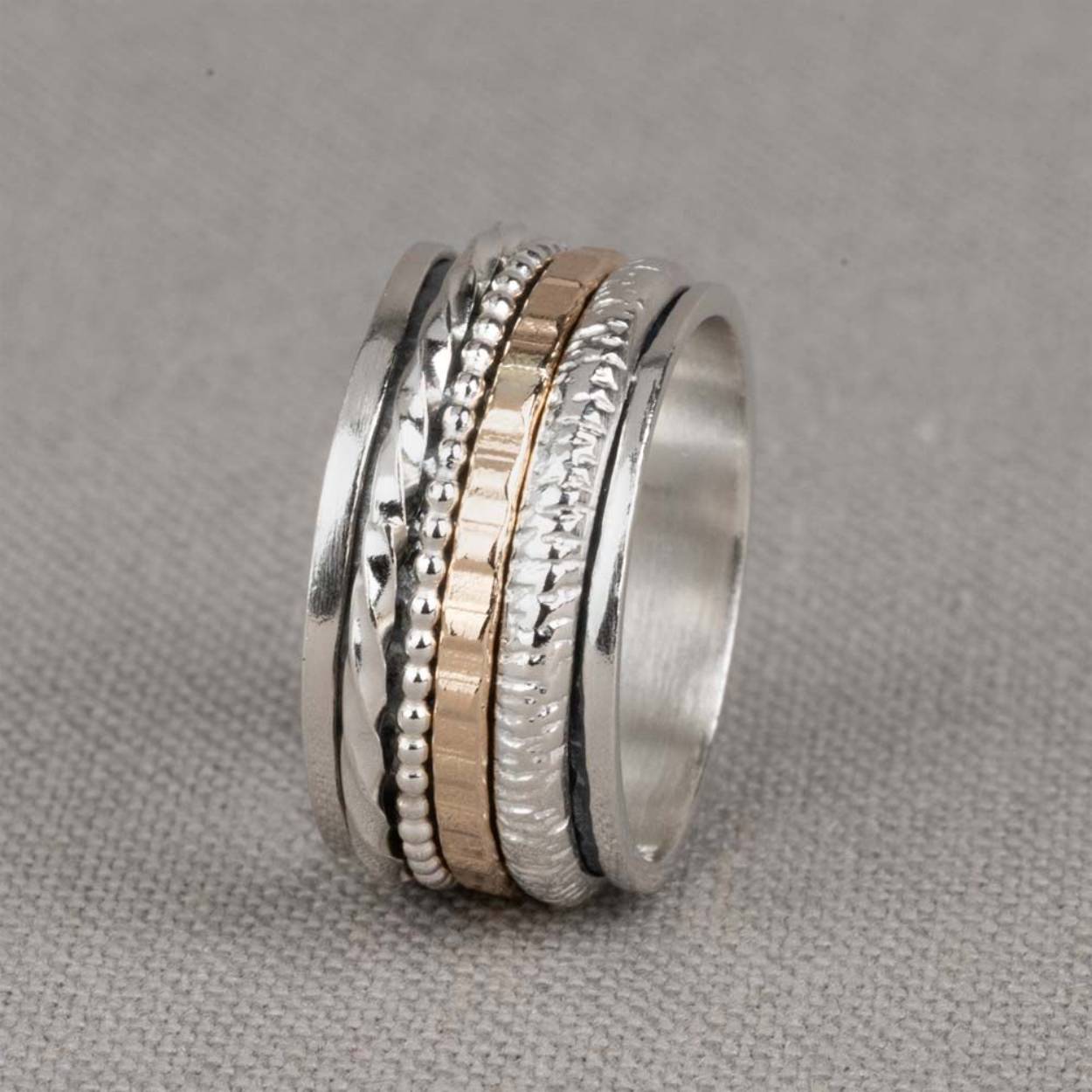 Bijzondere ring gemaakt van (geoxideerd) 925 sterling zilver en gold filled. De ringen in het midden van de ring kunnen bewegen, dit zorgt voor een speels effect. Onder de ring is gebruik gemaakt van geoxideerd zilver. Doordat de ringen speels bewegen, is het mogelijk dat de geoxideerde laag na verloop van tijd vervaagd.

Materiaal: Zilver
De glans van 925 sterling zilver maakt het een gewild edelmetaal voor de vervaardiging van sieraden. Het bestaat uit 92,5% puur zilver en 7,5% koper. Puur zilver is een zacht en buigzaam materiaal, het koper in 925 sterling zilver zorgt voor de stevigheid. De sieraden van Jéh Jewels zijn nikkel vrij.

Materiaal: Gold filled
Gold filled komt uit Amerika en wordt daar al langer gebruikt voor de vervaardiging van sieraden met een "touch of gold" voor een betaalbare prijs. Het gold filled blijft op kleur, is slijtvast en de goudlaag is dik genoeg om lang te kunnen genieten van de warme uitstraling van goud. Gold filled wordt veelal ook goed verdragen door mensen die allergisch zijn voor andere metalen dan goud.