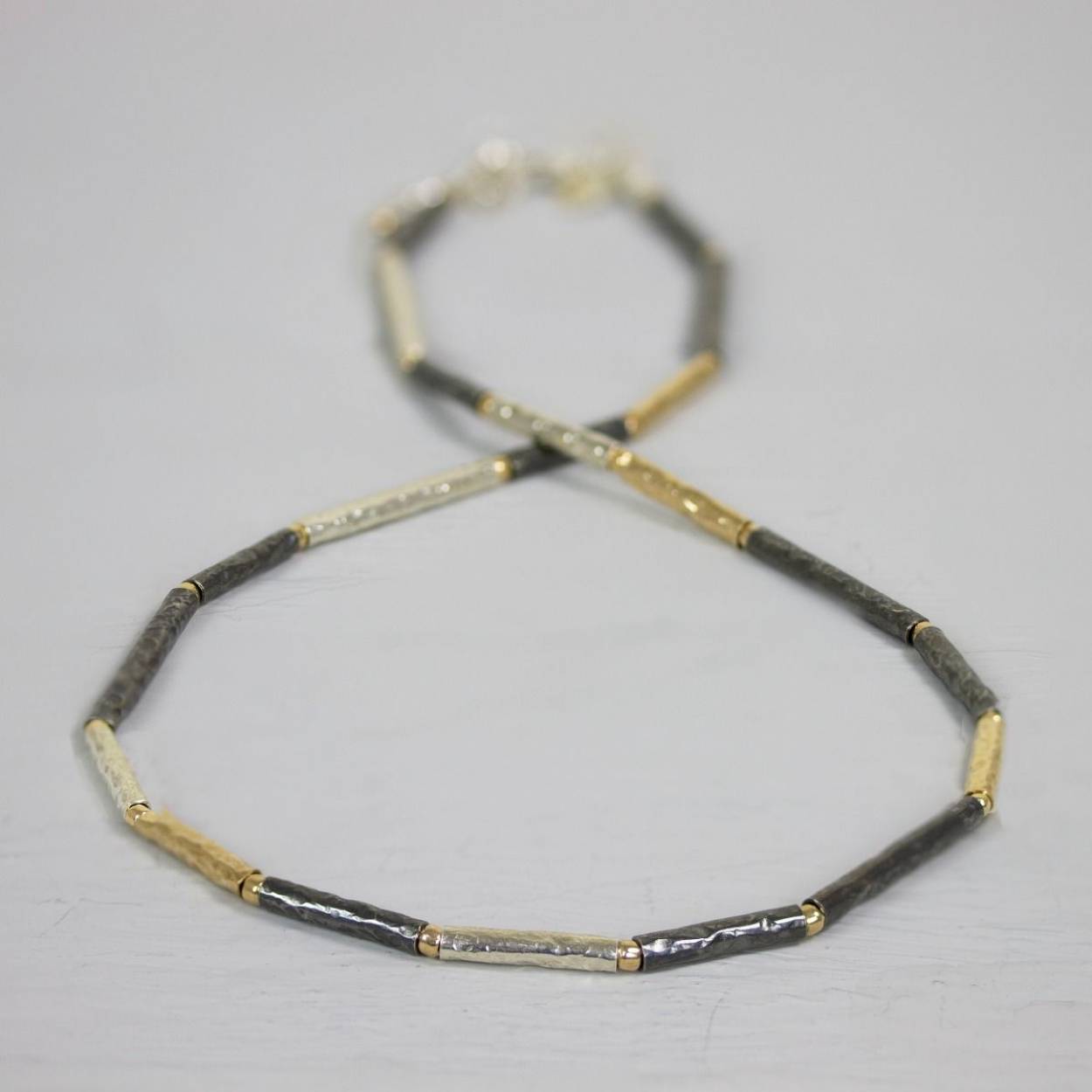 Collier van Jéh Jewels gemaakt van 925 (geoxideerd) sterling zilver met buisjes van goldfilled.

Lengte: 48 cm