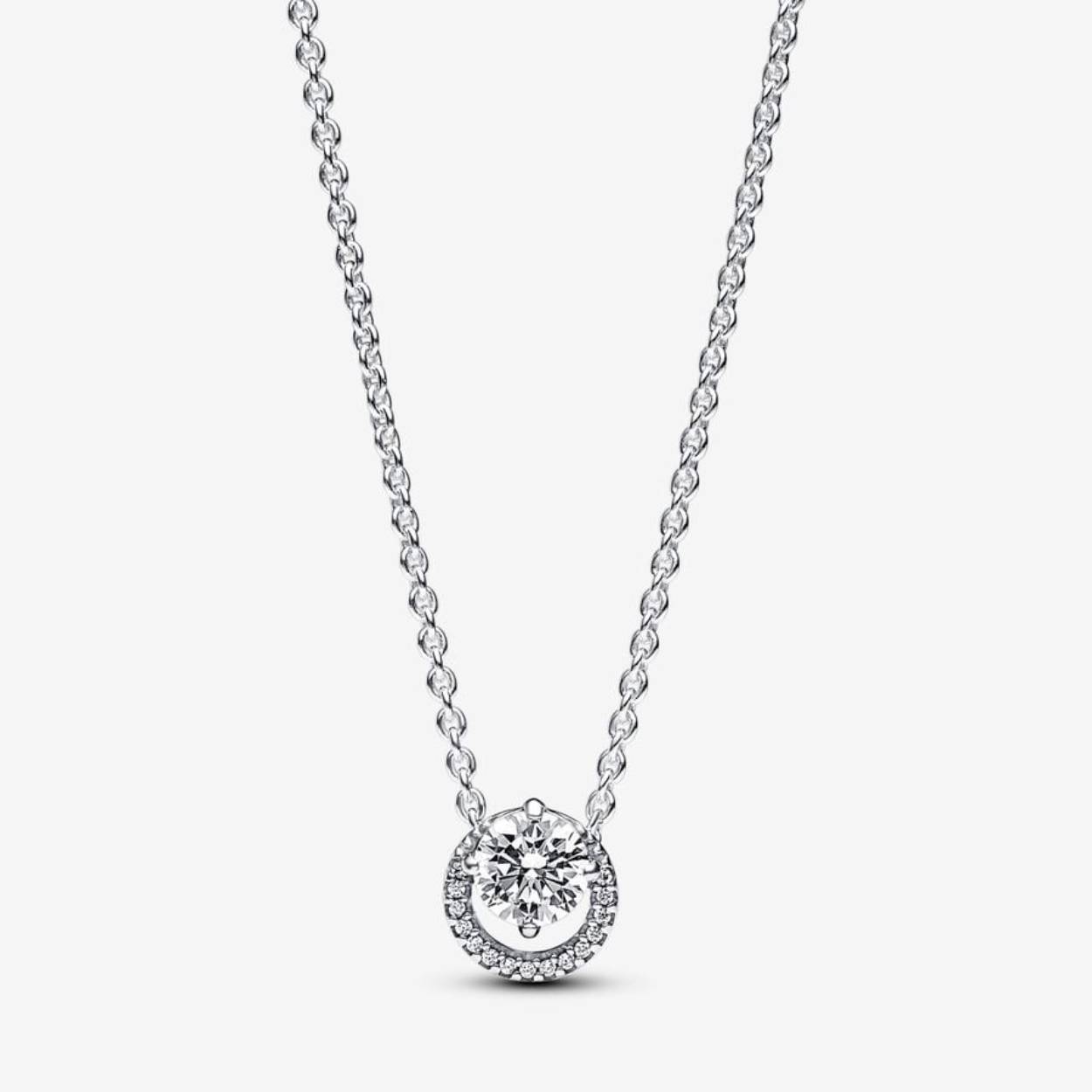 De sterlingzilveren sprankelende halsketting met ronde halohanger, versierd met heldere zirkonia, straalt tijdloze elegantie uit en vertegenwoordigt de blijvende schoonheid van cirkels. De hanger heeft een excentrische ronde steen in klauwzetting die een pavé halo subtiel overlapt, zodat hij vrij kan schuiven langs de verstelbare kabelketting van 38 cm, 42 cm of 45 cm. Deze halsketting met een gegraveerd Pandora-logo en een hangende steen aan de karabijnsluiting geeft elke look een verfijnde uitstraling. Het perfecte cadeau voor wie waarde hecht aan klassieke schoonheid en elegantie.