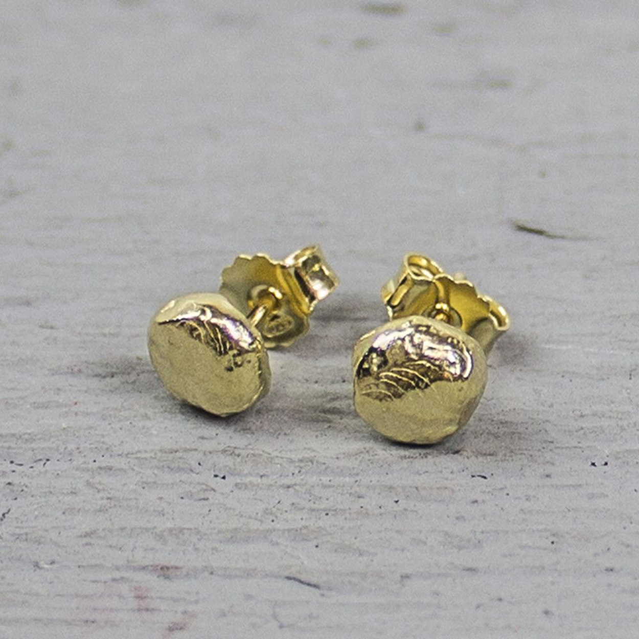 Oorknop rond gemaakt van zilver verguld en bewerkt met hamerslag.

Materiaal: Zilver verguld
Vergulden is het bedekken van een voorwerp met een laagje goud. Dit artikel is door een goudbad gehaald wat ervoor zorgt dat het zilver volledig bedekt wordt met een laagje goud. Resultaat een mooie glanzende afwerking met een laagje echt goud wat ook wel silverplated of goldplated wordt genoemd.