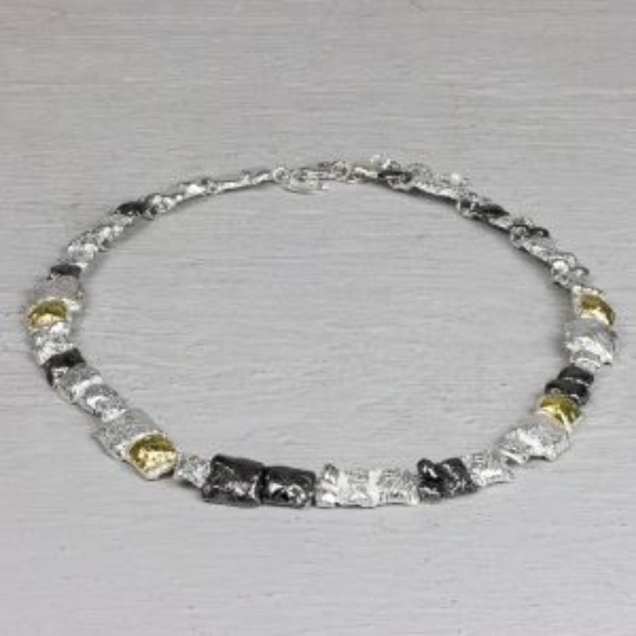  Dit collier is gemaakt van drie soorten zilver. Namelijk 925 sterling zilver, geoxideerd en verguld zilver. Door deze kleurencombinatie is dit collier makkelijk te verwerken in elke soort look. 

