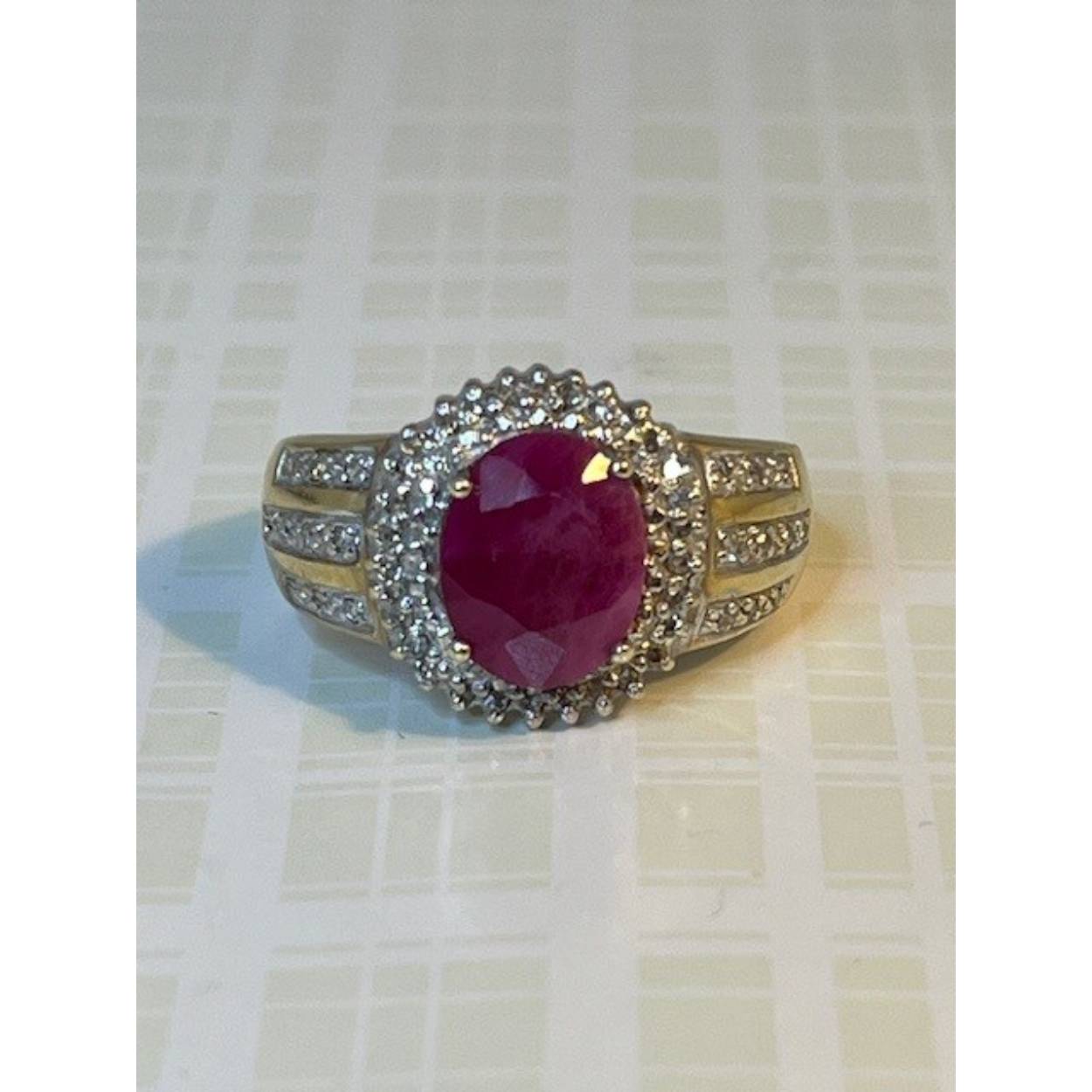 Deze prachtige vintage gouden ring heeft een opvallende roze robijn. Om de robijn heen zijn kleine, briljant geslepen diamantjes pavé gezet. De scheen is 1,2 mm breed en de kop van de ring is 7,2 bij 6,7mm. De roze robijn is 5 bij 4mm.
