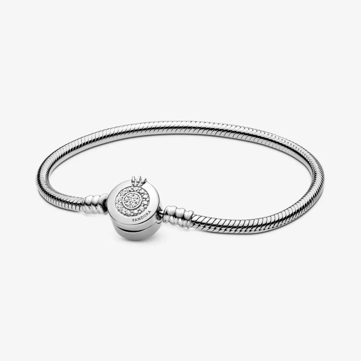 Breng wat glans in je dag met de Pandora Moments sprankelende Crown O snake chain-armband. Deze armband is hand-finished in sterlingzilver en heeft een sluiting met het iconische Pandora Crown O-monogram en twee cirkels van heldere zirkonia in pav&eacute;zetting. Een ander iconische Pandora-designelement, het snake chain, is een chique en moderne touch rond je pols. Stapel met andere armbanden en hang ze vol met je favoriete bedels voor een stuk dat je telkens weer draagt.