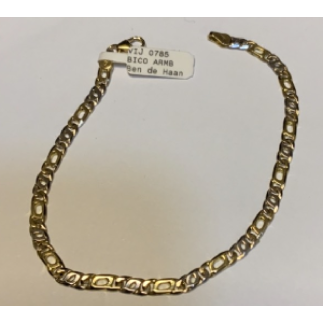 Bicolour armband, 1 kleine witgouden valkenoog schakeltje en dan 1 grotere geelgouden valkenoog schakel. 19,5 cm, 3,6 mm.