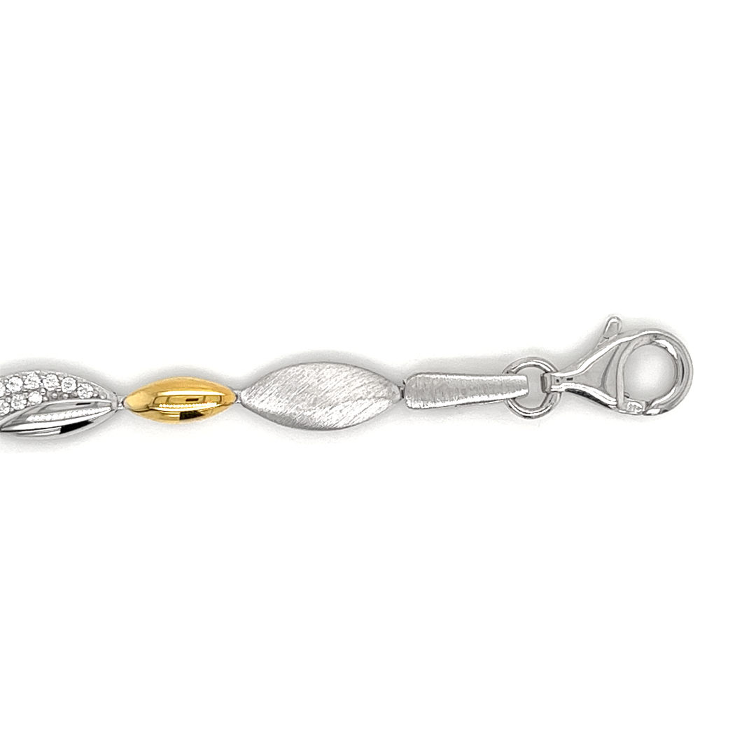 Deze armband is gemaakt van 925 zilver. De armband is gedeeltelijk gematteerd en gedeeltelijk glad gepolijst, de combinatie van mat/ glans geeft deze armband een erg mooie uitstraling. De glanzende schakels zijn gedeeltelijk gezet met zirkonia steentjes. De kleinste schakels zijn zilver verguld (goudkleur). Ook heeft de armband heeft een stevig karabijnslot.