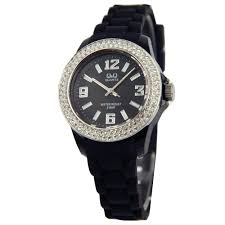 MEISJES HORLOGE MET EEN GLIMMENDE RAND BOVENOP DE KAST. DE KAST IS VAN STAAL EN DE ZWARTE BAND VAN RUBBER