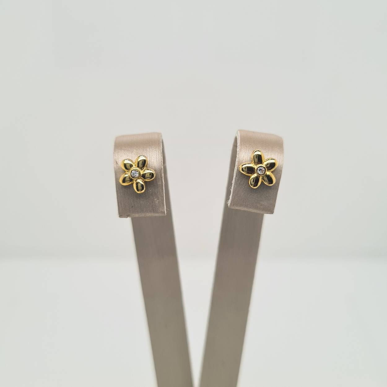 Geelgouden oorknoppen in de vorm van een bloem. Uitgevoerd met een schitterende zirkonia. 
Tip: Leuk om kado te geven! Zie je ze al stralen?