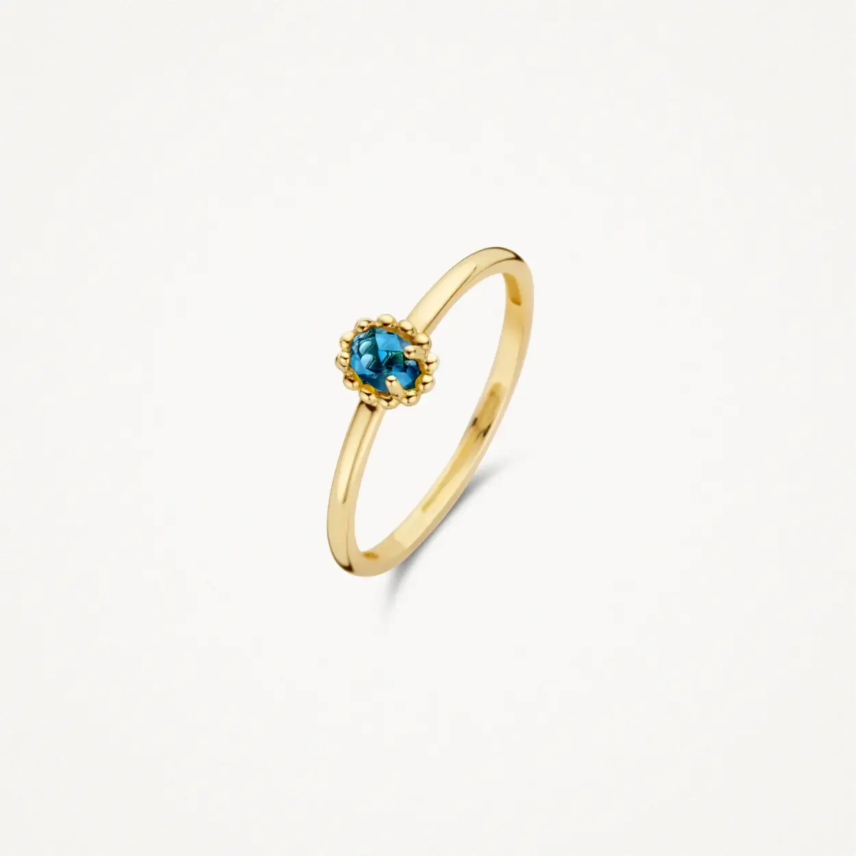 Deze ring van 14k geelgoud met blauwe topaas valt op door de speelse zetting, een bolletjesmotief waaruit vier pootjes omhoogkomen die de topaas vasthouden. De band heeft een doorsnede van 1,3 mm. Mooi op zichzelf of in combinatie met andere ringen uit onze collectie.