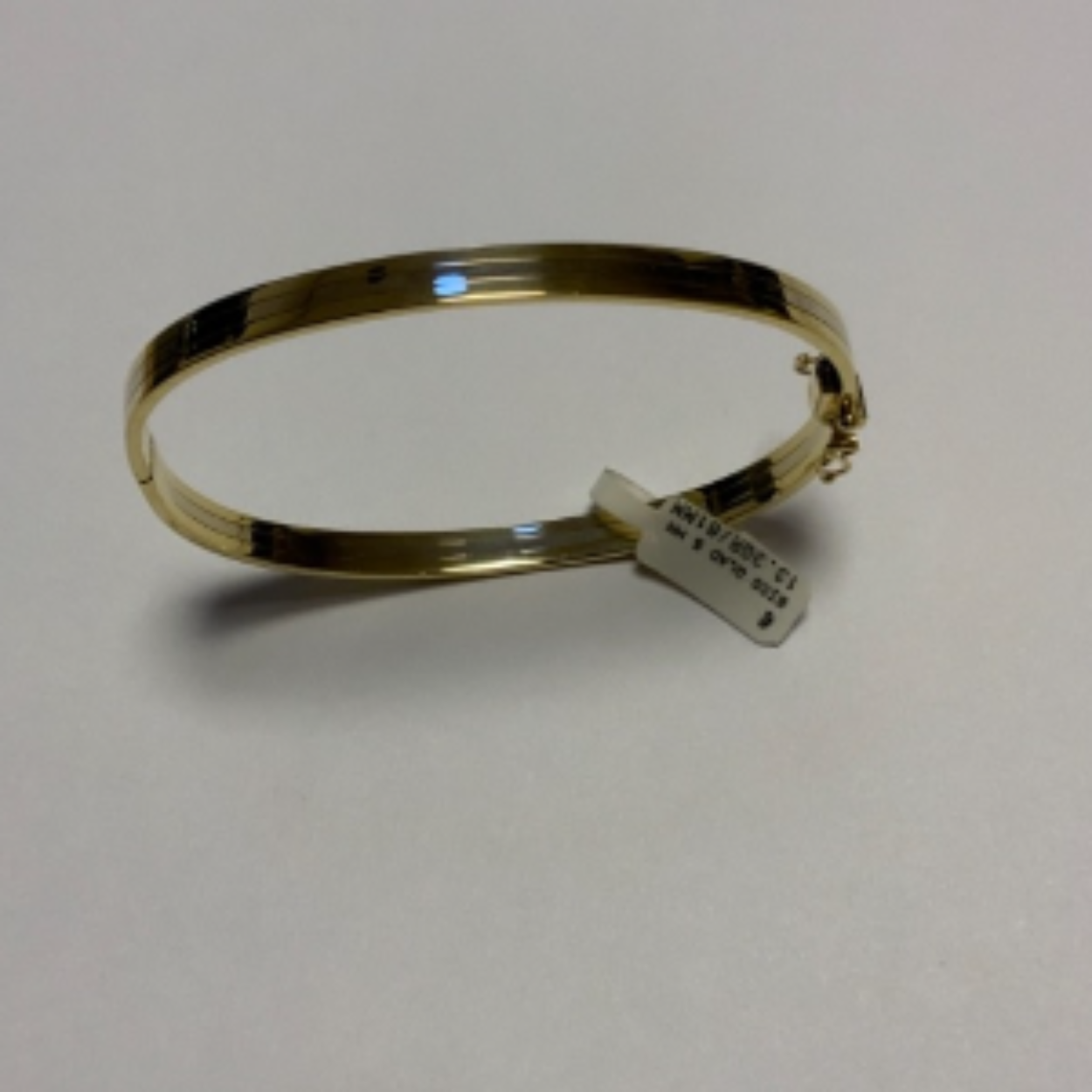 Bicolour gladde bangle armband. De buitenbanen zijn geel, de middenbaan is wit. Met scharnier, baksluiting en 2x vh8. 
Doorsnede; 61 mm
Breedte; 5 mm