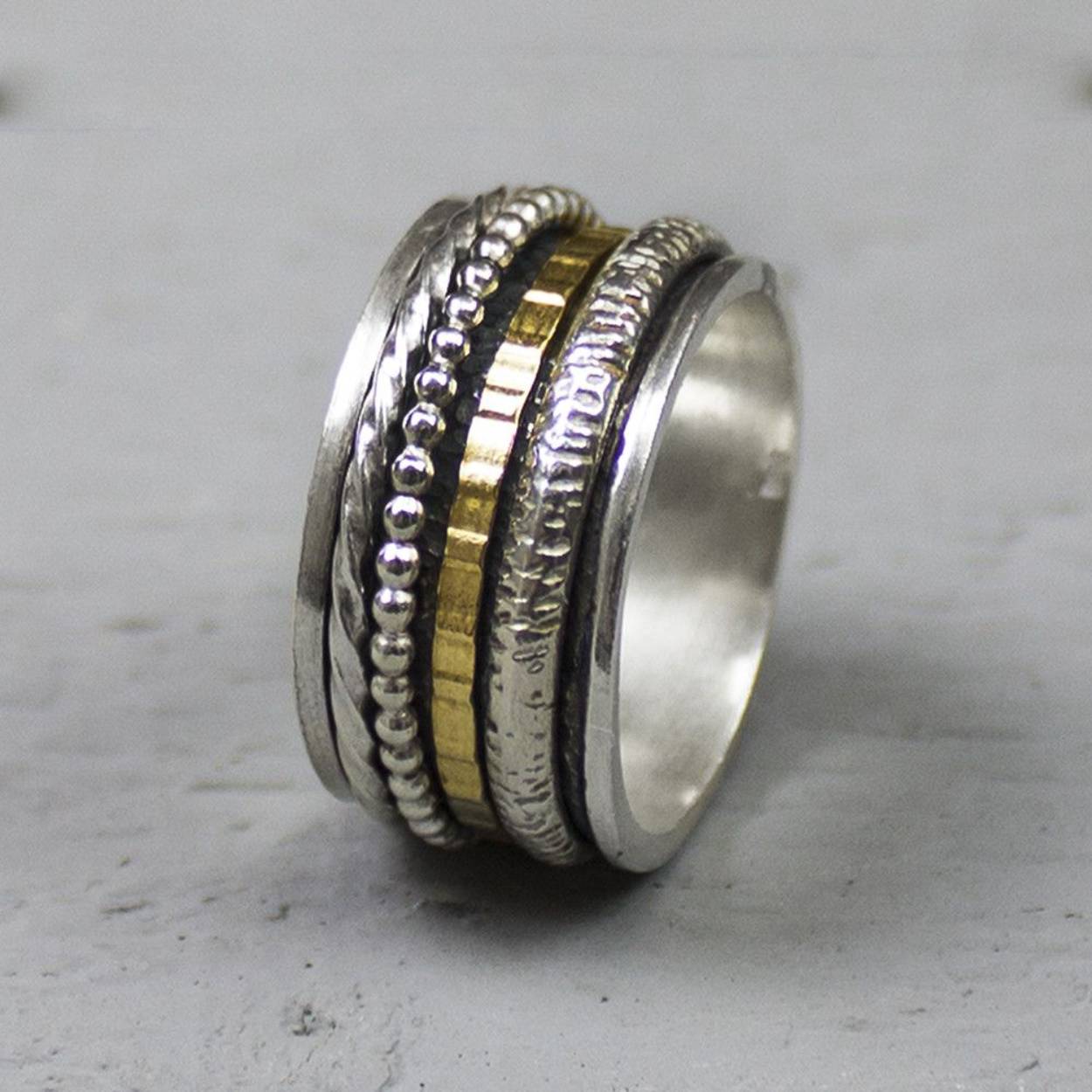 Bijzondere ring gemaakt van (geoxideerd) 925 sterling zilver en gold filled. De ringen in het midden van de ring kunnen bewegen, dit zorgt voor een speels effect. Onder de ring is gebruik gemaakt van geoxideerd zilver. Doordat de ringen speels bewegen, is het mogelijk dat de geoxideerde laag na verloop van tijd vervaagd.