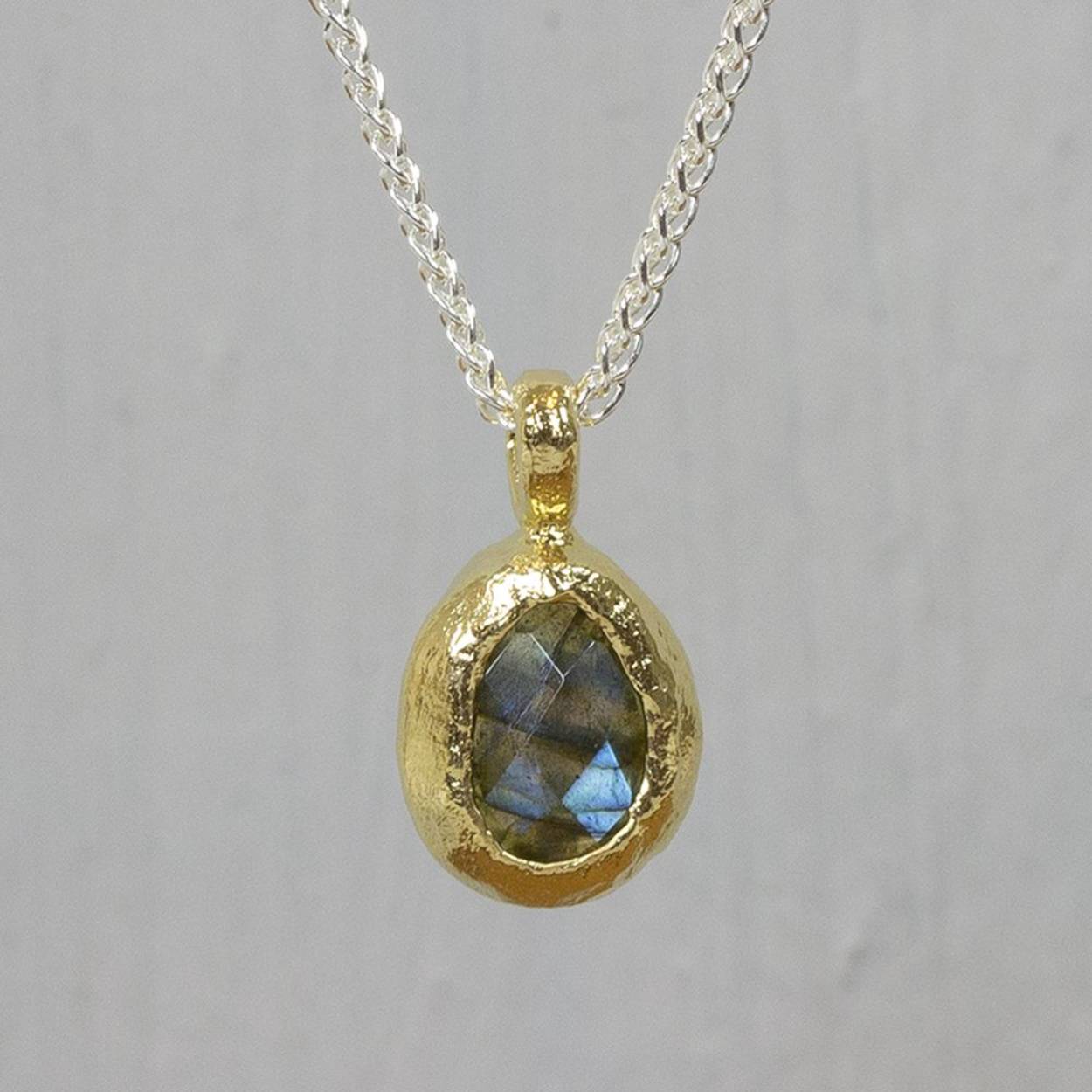 Collier gemaakt van 925 sterling zilver. Aan het collier hangt een gefacetteerde Labradoriet, omhult met zilver verguld. Labradoriet is een sterk beschermende en spirituele steen. Het beschermt het eigen energieveld (aura) tegen negatieve invloeden uit de omgeving.