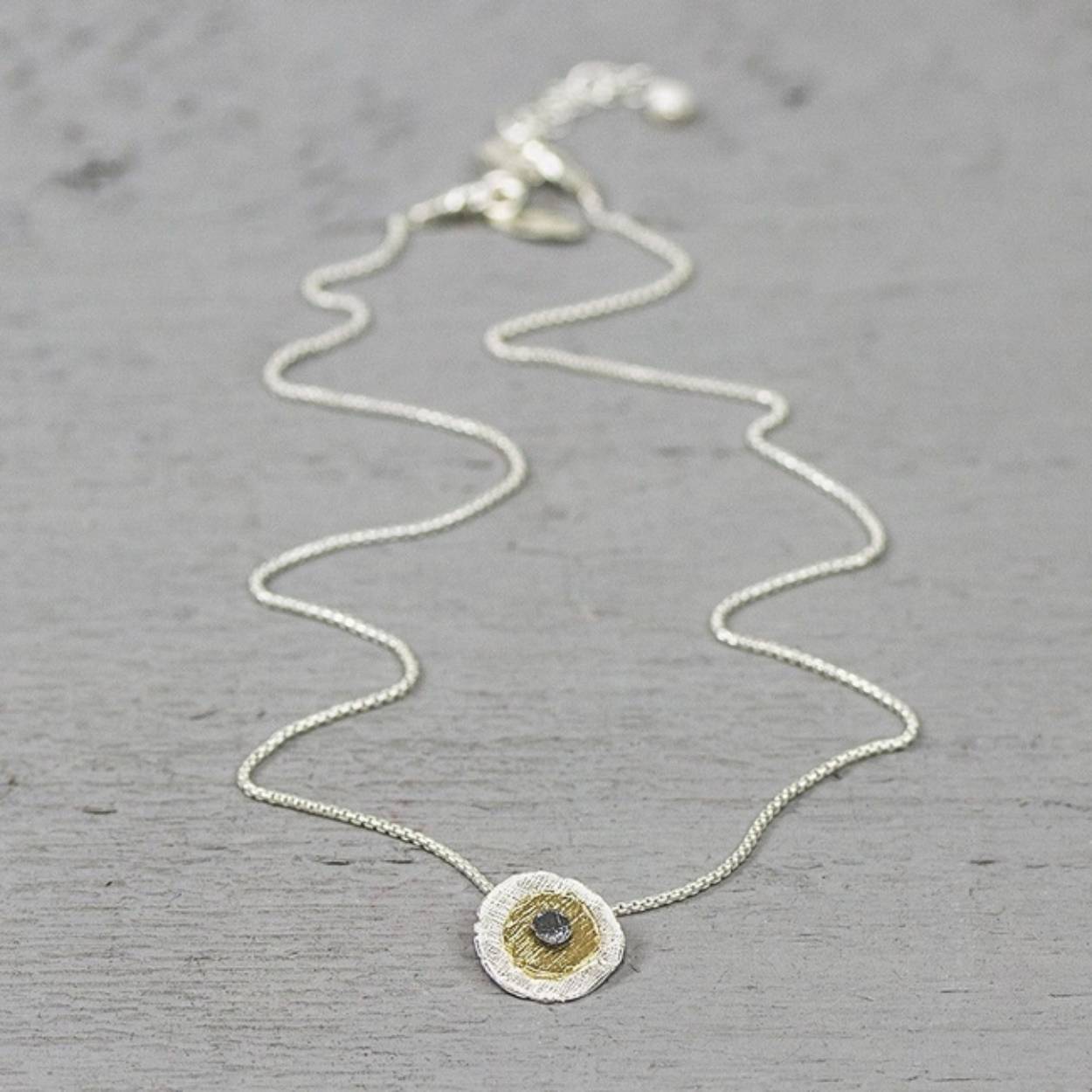 Dit prachtige collier is gemaakt van 925 sterling zilver, geoxideerd zilver en G14K verguld. Dit collier heeft een lengte van 42 cm. De hanger is 1,3 cm breedt.