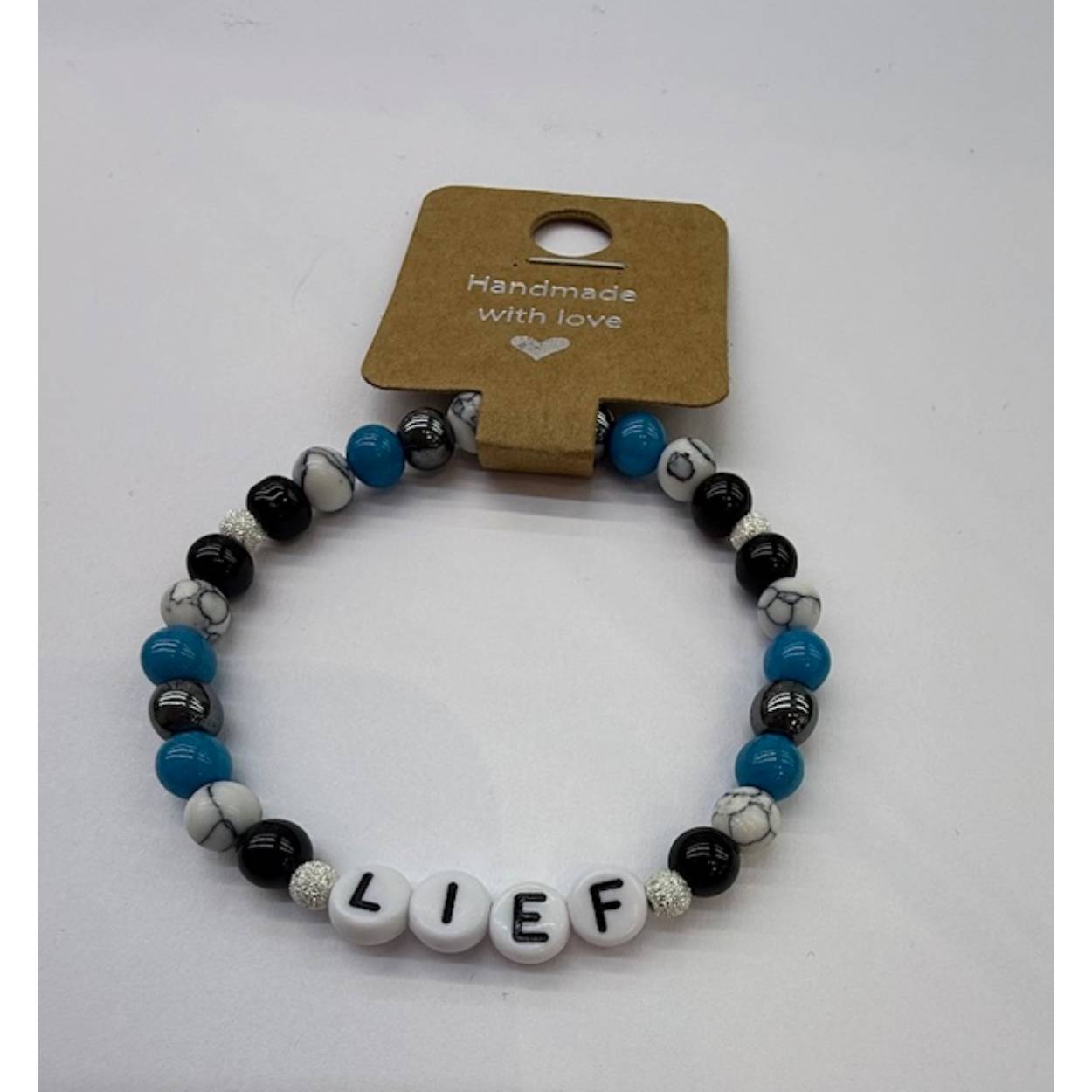 FOY ARMBANDJE . LIEF ARMBANDJE MET POSITIEVE TEKST EN ZILVEREN BALLETJES .