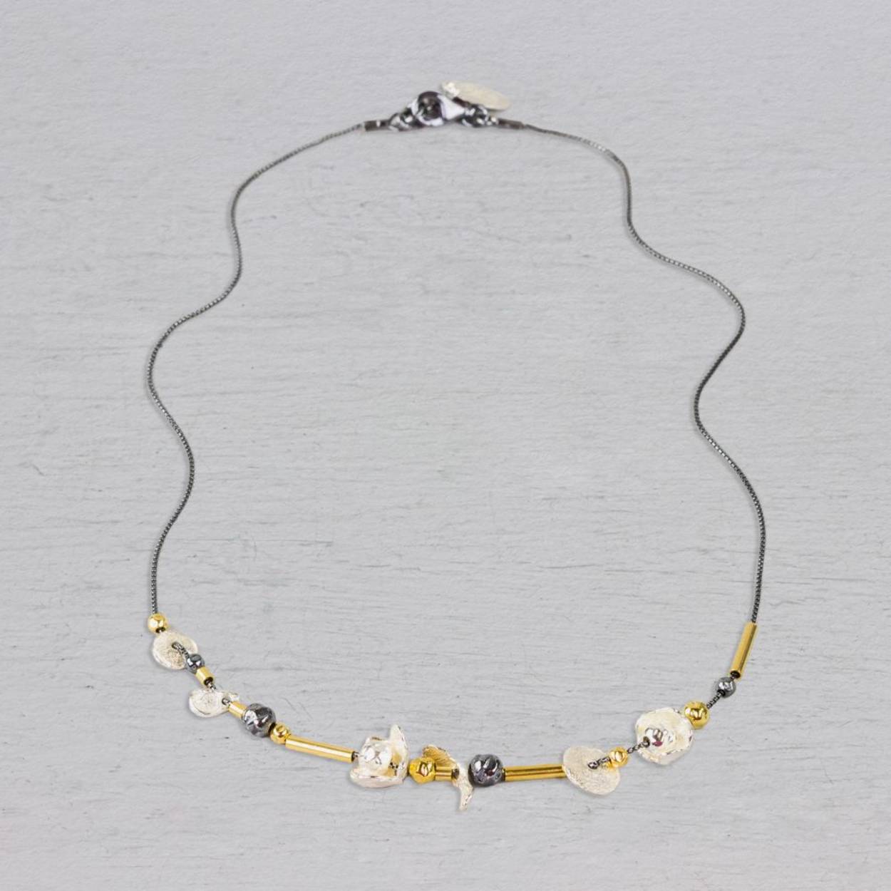 Collier met buisjes, balletjes en bloemetjes. Gemaakt van 925 (geoxideerd) sterling zilver en Goldfilled. Combineer met mooie oorsieraden, een ring en armband. Het collier is verstelbaar waardoor je hem ook op een andere lengte kunt dragen.