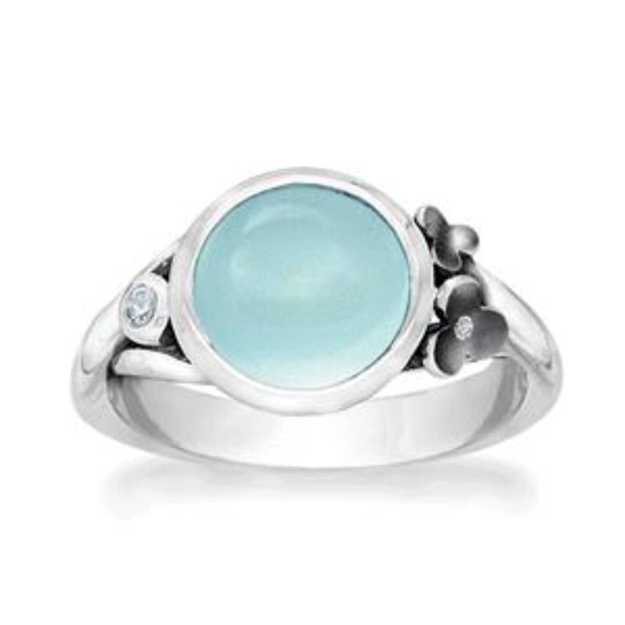 Deze sterling zilveren ring heeft een mooie 10 mm blauwe chalcedoon. De ring is mooi afgewerkt met een zilveren bloemetje welke een 1 mm zirkonia bevat en aan de andere kant een 2 mm blauwe topaas bevat.