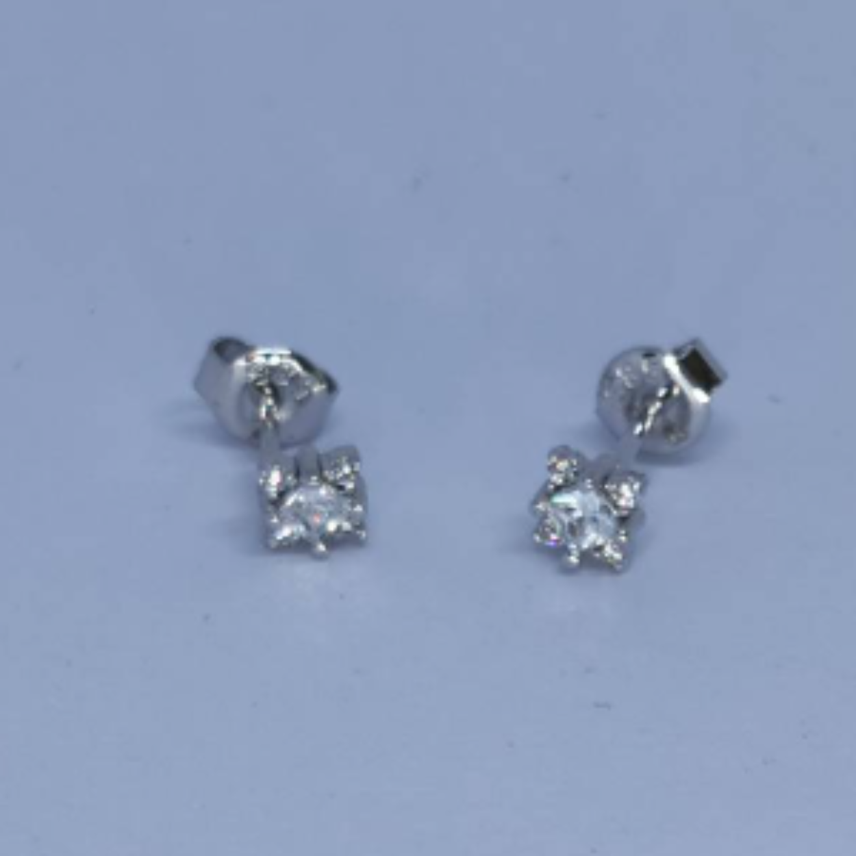 14 Karaat wit gouden solitair oorstekers met in de centre een princess cut zirkonia en vier briljant geslepen zirkonia in klauwzetting.

Deze oorstekers zijn ook leverbaar met briljant geslepen diamant, zie artikel EBOD0013.