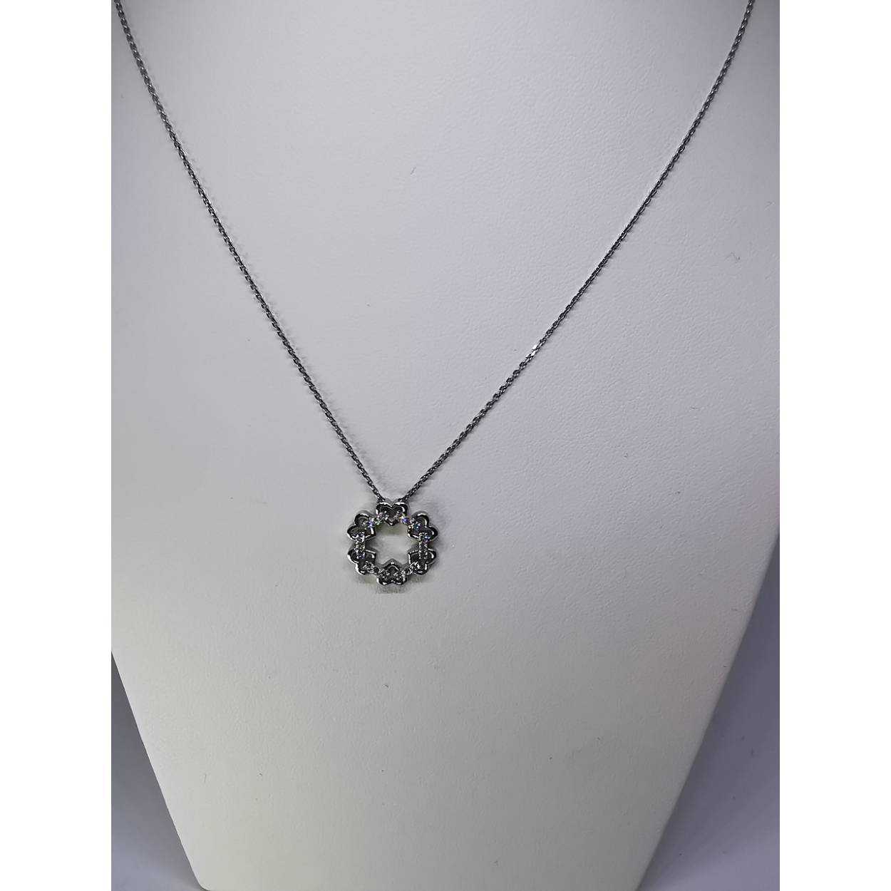 14 karaat wit gouden anker schakel collier met bloem/hart hanger. De hanger bestaat uit zes opengewerkte hartjes verbonden met zirkonia bezette staafjes.

3.15 gram
44 cm lang